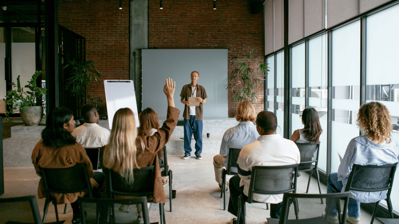 Man public speaking in front of 8 people