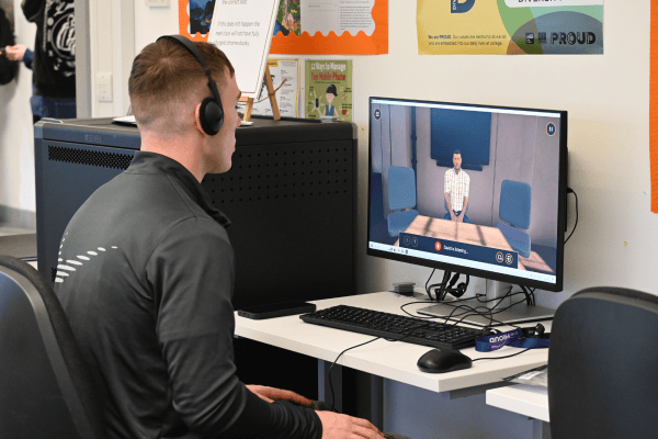 Male student sitting in front of a desktop computer using Bodyswaps