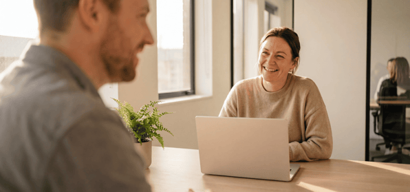 Meeting between two staff members in an open plan office