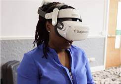 Woman wearing a VR headset sitting in a clinic.