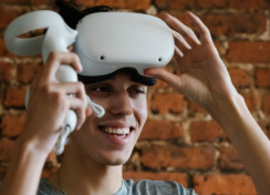 Man using VR headset with a brick background.