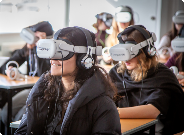 Students wearing VR headsets in a classroom while sitting at their desks.