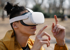 Man wearing a VR headset in a yellow rain jacket looking upwards.