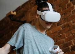 Male student in a grey shirt wearing a white VR headset.