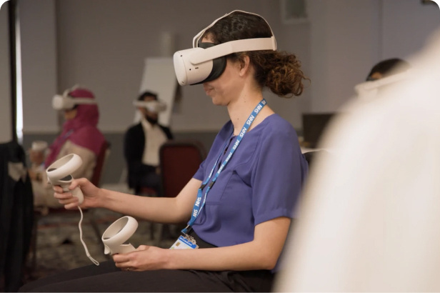 Lady in corporate clothing, seated in a training room with VR headset on