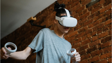 Male student in a grey shirt wearing a white VR headset 