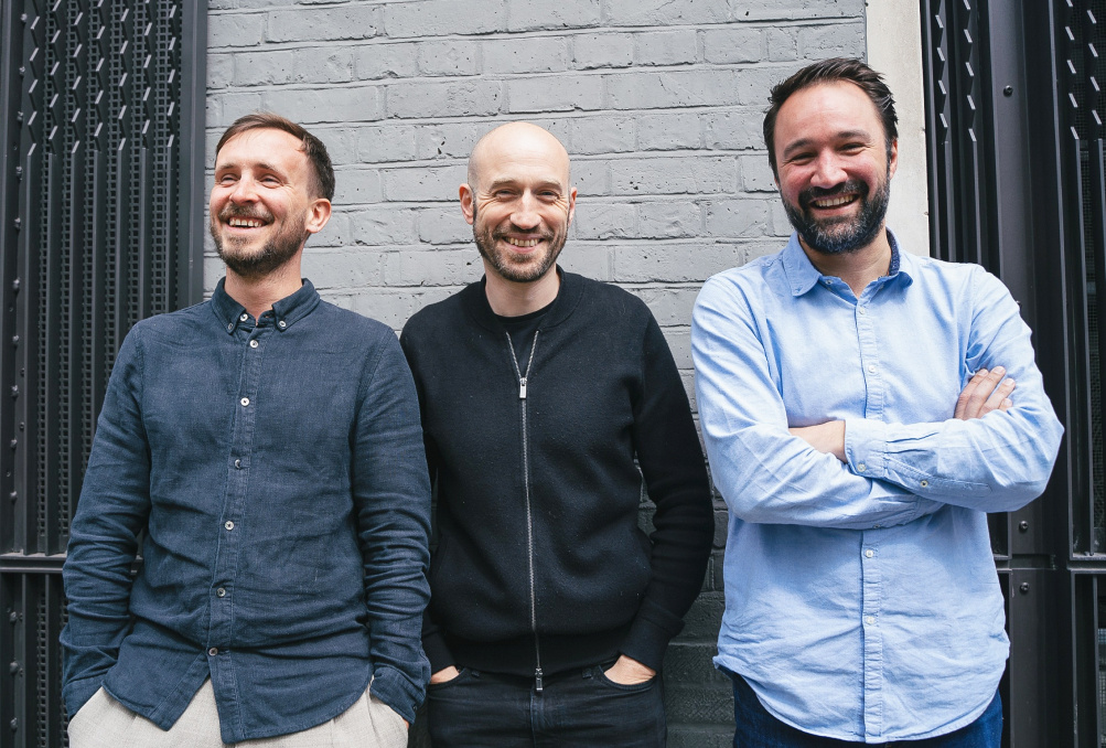 Stock image of three people next to each other laughing